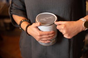 Nemiskacat Enikő egy Annie Sloan krétafestéket bont fel éppen egy doboznyitóval